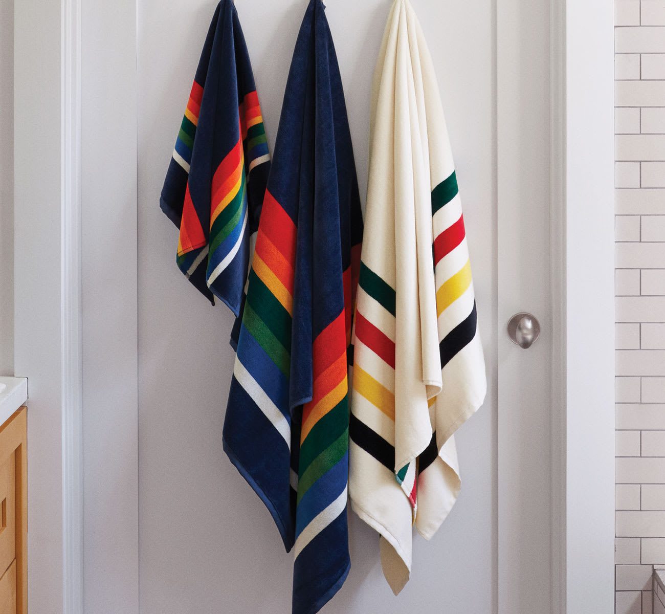 Bath Towels Hanging From Hooks On A Wall