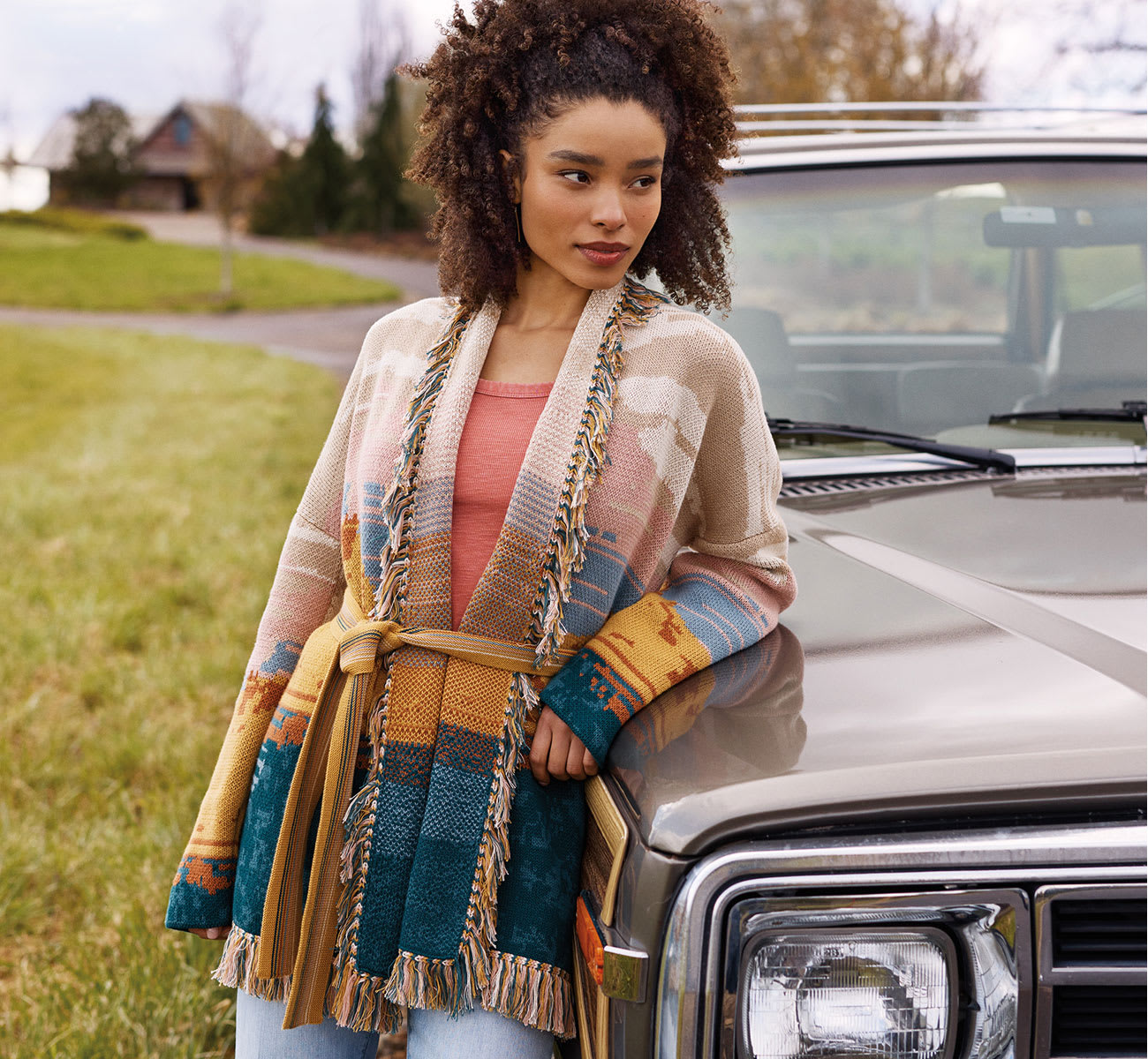 Woman Wearing a Patterned Sweater Leaning On A Car